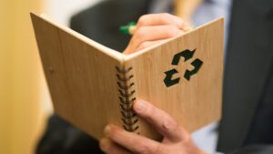 Persona che scrive su un taccuino riciclabile